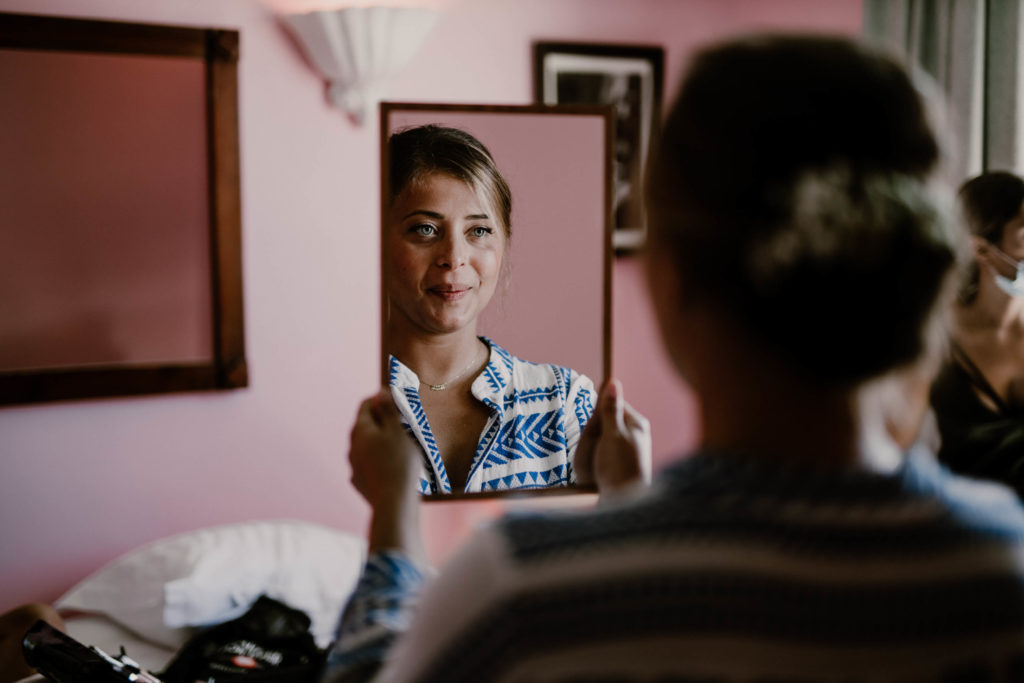 la mariée heureuse se regardfe dans son miroir pour son mariage à nice