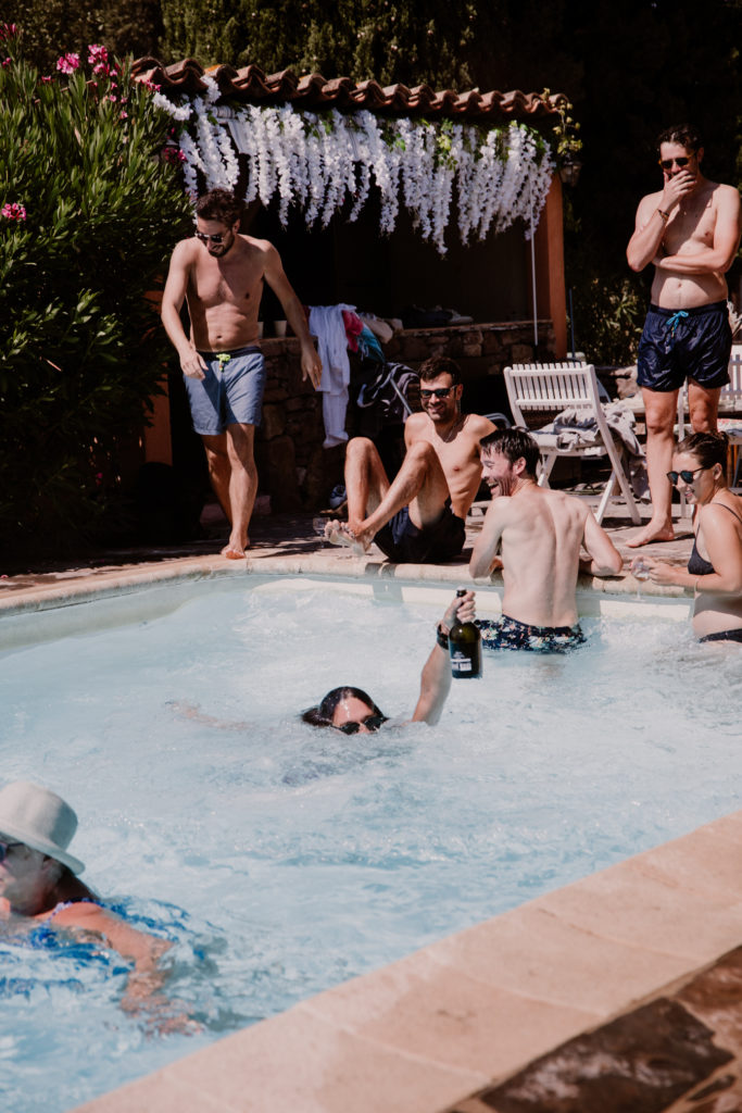 Un invité boit du champagne dans la piscine du château de Vaucouleurs lors d'un mariage