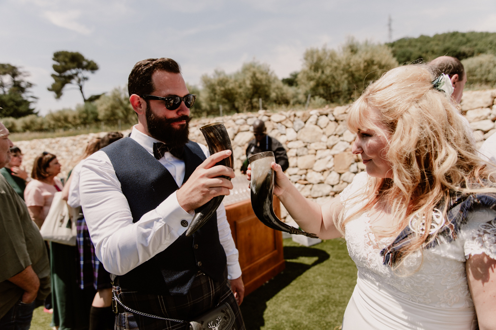 Les mariés trinquent dans des cornes pendant leur mariage sur le thème écossais au Domaine de Tourris au Revest