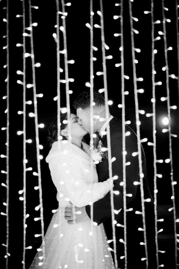 Photo d'un couple de mariés derrière un rideau de lumière