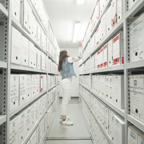 Une personne classe des archives au CDG83